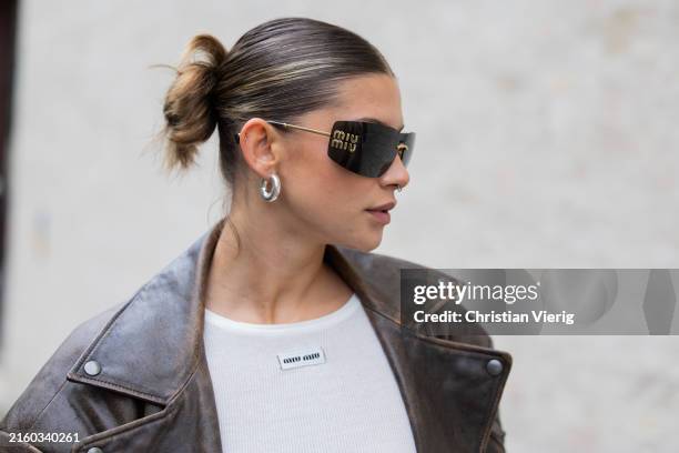 Sophia Geiss wears white dress Miu Miu, brown leather jacket Ducie London, sunglasses Miu Miu during the Berlin Fashion Week SS25 on July 02, 2024 in...