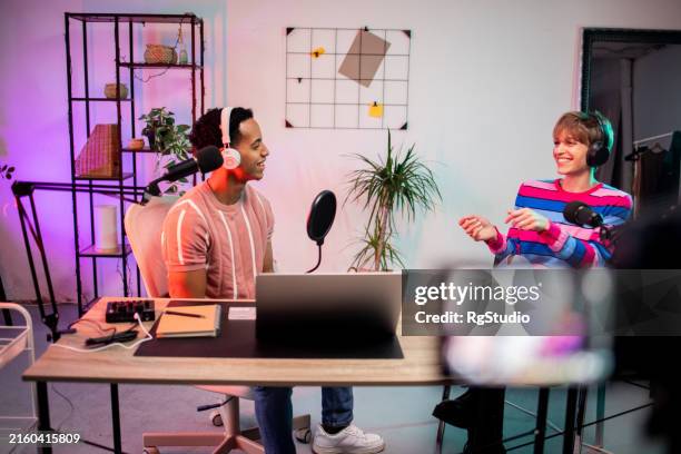 dos jóvenes periodistas conducen un programa de radio en vivo - locutora de radio fotografías e imágenes de stock