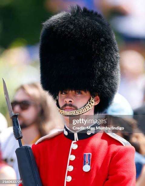 Moustachioed soldier of the Grenadier Guards seen standing on The Mall ahead of a carriage procession transporting King Charles III, Emperor Naruhito...