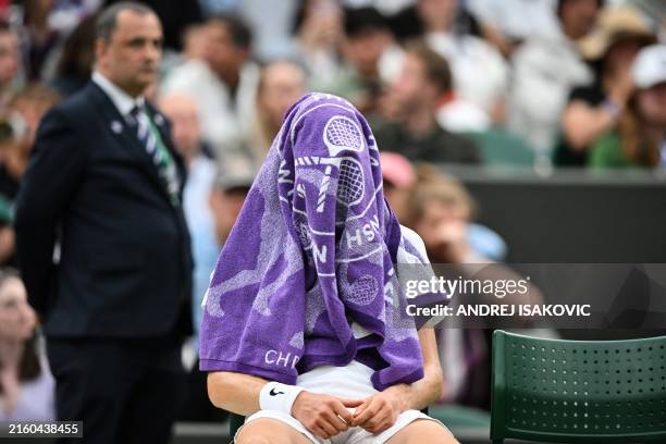 Italy's Jannik Sinner cover his face with a towel as he plays against USA's Ben Shelton during their men's singles tennis match on the seventh day of...