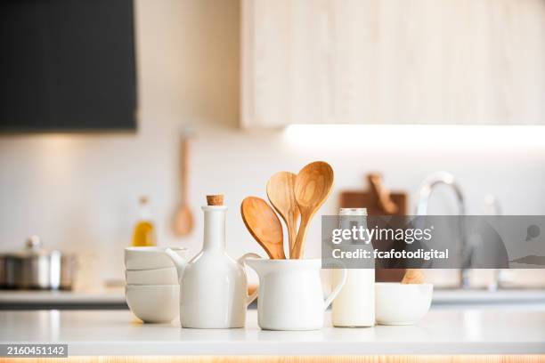 kitchen counter with white crockery and wooden kitchen utensils. selective focus on foreground - loja de utensílios de cozinha imagens e fotografias de stock
