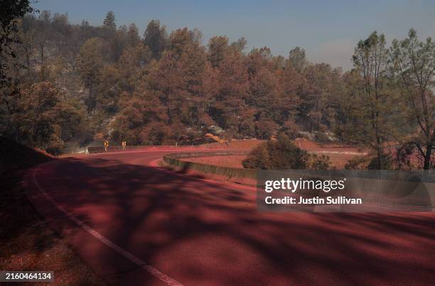 Phos-Chek fire retardant covers a road after the Thompson Fire moved through the area on July 03, 2024 in Oroville, California. At least 12,000 Butte...