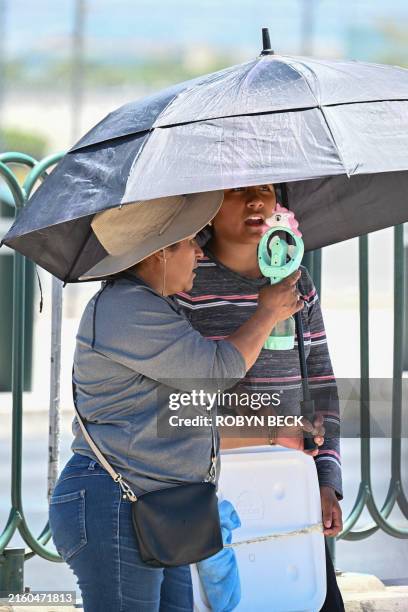 Vendors selling water try to stay cool during a heatwave in Las Vegas, Nevada on July 7, 2024. According to the US National Weather Service, high...