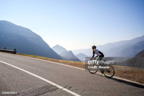 woman road cycling on italian alpine road - ciclista foto e immagini stock