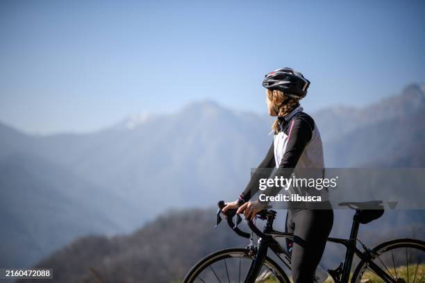 woman road cycling on italian alpine road - road cycling stock pictures, royalty-free photos & images