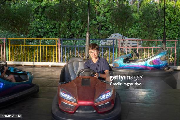young boys having fun driving bumper car at amusement park - funny accident stock pictures, royalty-free photos & images