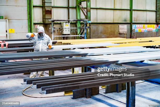 a painter is painting a steel surface white - spray gun stock pictures, royalty-free photos & images