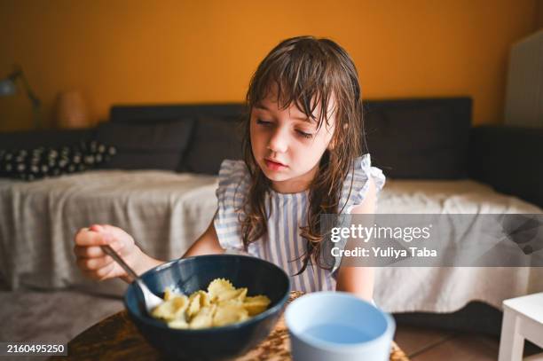 child tasting tortellini. - tortellini stock pictures, royalty-free photos & images