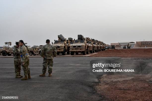 American soldiers in front of military vehicles that they are preparing to board a cargo plane in Niamey on June 7, 2024 during the ceremony for the...