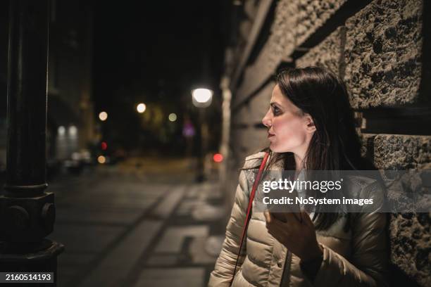 nighttime smartphone use by streetlamp - woman midnight stock pictures, royalty-free photos & images