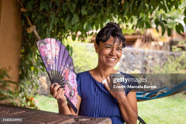 femme hispanique transpirant avec un ventilateur par temps chaud - éventail photos et images de collection