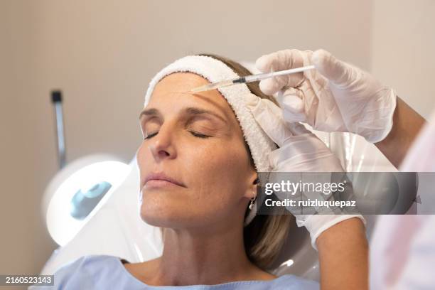dermatologist and beautician applying mesotherapy injections on patient - botulinetoxine injectie stockfoto's en -beelden