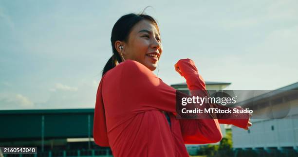 closeup of young asian female athlete runner stretching warm up exercise before running exercise getting ready for jogging outdoors. healthy workout exercise. - warm up exercise stock pictures, royalty-free photos & images