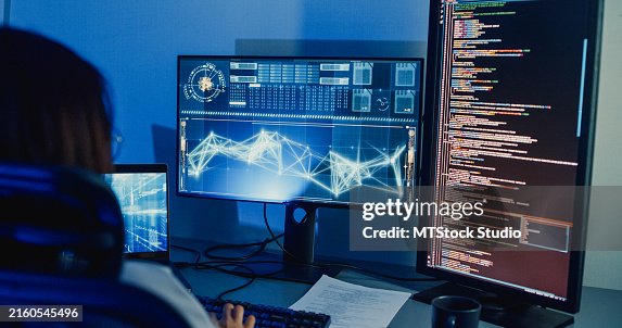 Closeup Asian woman software developers using computer to write code application program for AI technology at desk with multiple screens work at home office night. Programmer development. Closeup Asian woman software developers using computer to write code application program for AI technology at desk with multiple screens work at home office night. Programmer development.