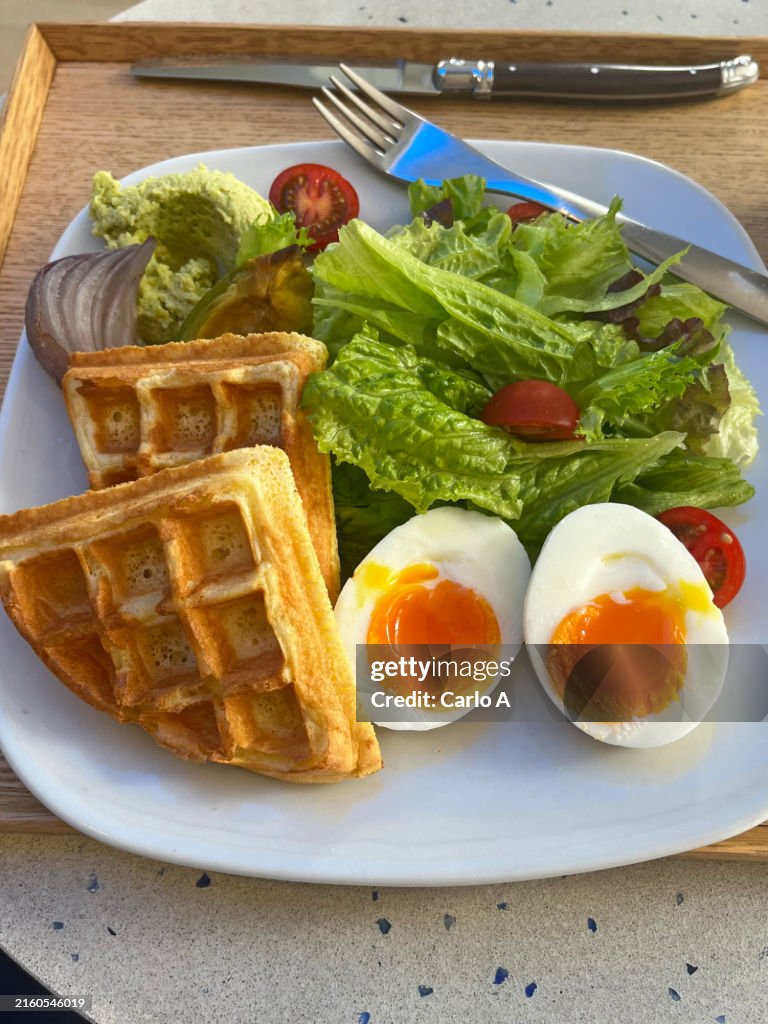 Waffles, salad and boiled eggs at cafe