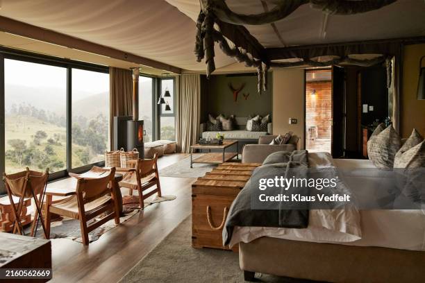 bed with furniture and large window in rental villa - safari lodge stock pictures, royalty-free photos & images