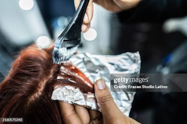 close-up of a hairdresser dyeing customer hair on hair saloon - hair color stock pictures, royalty-free photos & images