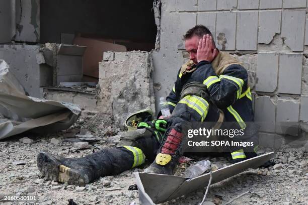 Tired firefighter sits near the Okhmatdit Children's Clinic, which was damaged after a rocket attack. In the morning, the Russian army carried out a...