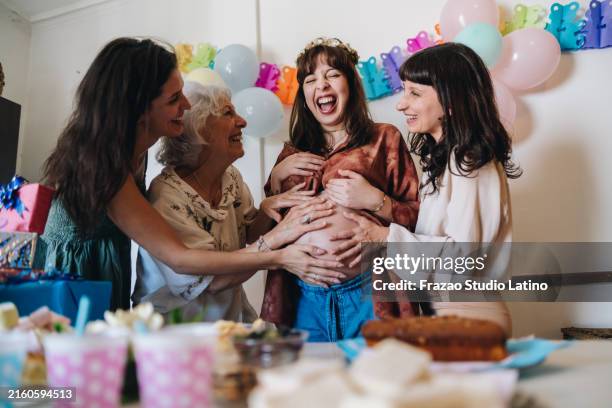familie feiert babyparty zu hause - alte und junge lesbische frauen stock-fotos und bilder