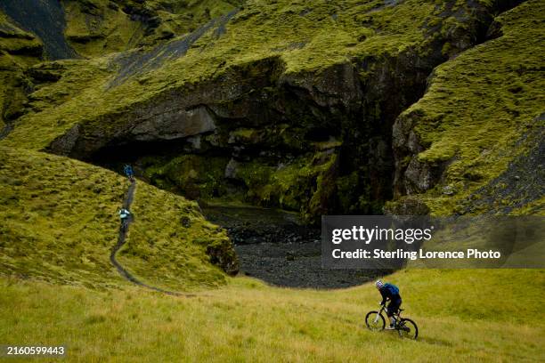 mountain biking in iceland amongst volcanic rock terrain, moss and green grasses - northern europe stock pictures, royalty-free photos & images
