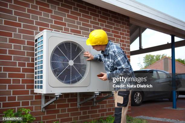 air source heat pump fitted outside a new home development - heating system stock pictures, royalty-free photos & images