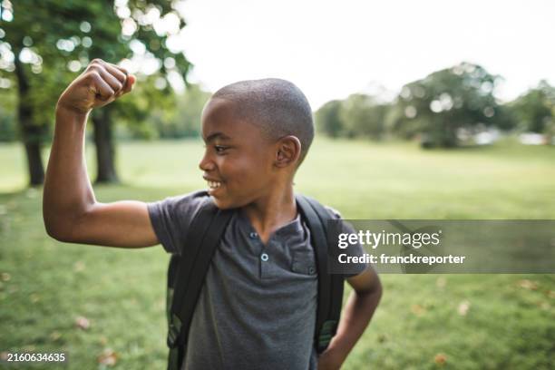 petit enfant montrant le muscle - musculation des biceps photos et images de collection