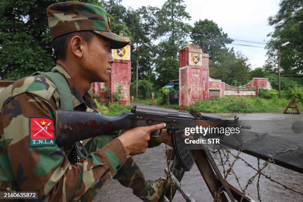 This photo taken on July 3, 2024 shows a member of the ethnic armed group Ta'ang National Liberation Army keeping watch at a checkpoint in the town...