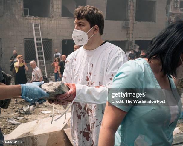 Medical worker wearing a blood-soaked coat helps remove debris at Okhmatdyt Children's hospital, in Kyiv, Ukraine, on July 8, 2024. Several attacks...