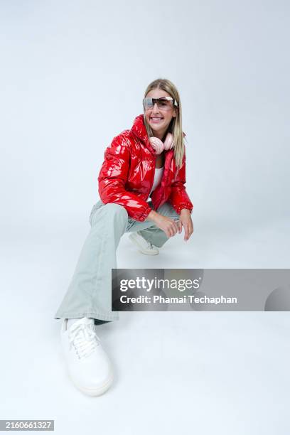 happy energetic woman on plain background - flare pants stock pictures, royalty-free photos & images
