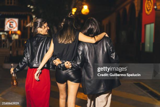 group of girlfriends walking down the street at night - dronken stockfoto's en -beelden