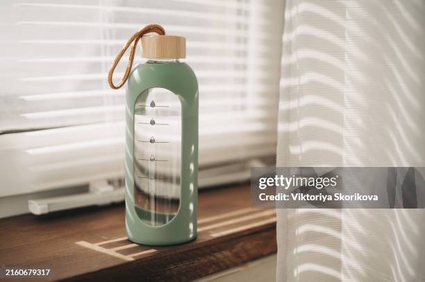 series of images with a bottle and glass of water with setting sun and sea in background - water bottle stock pictures, royalty-free photos & images