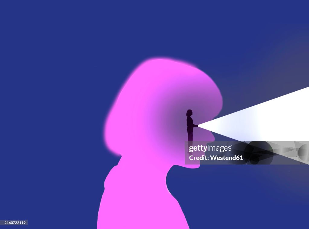 Woman shining flashlight through eyes of oversized womans head