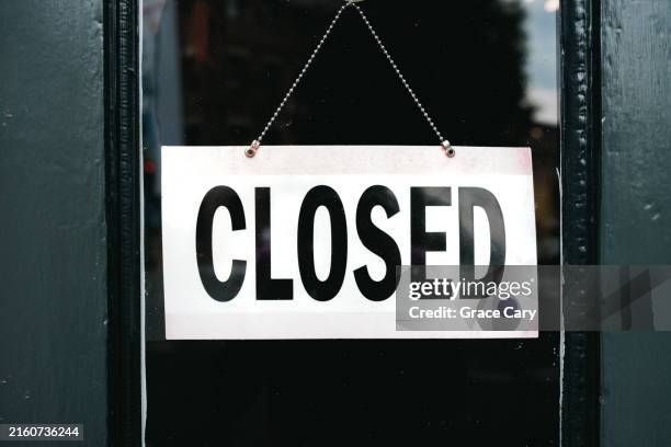 closed sign hangs on store door - fermé photos et images de collection