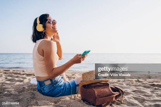 a young woman listens to music on the sea - relax music stock pictures, royalty-free photos & images