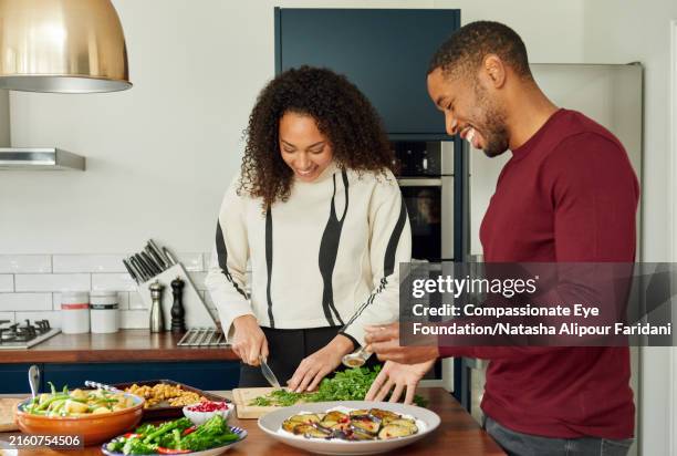cheerful man and teenager prepare lunch at family gathering - chopping stock pictures, royalty-free photos & images
