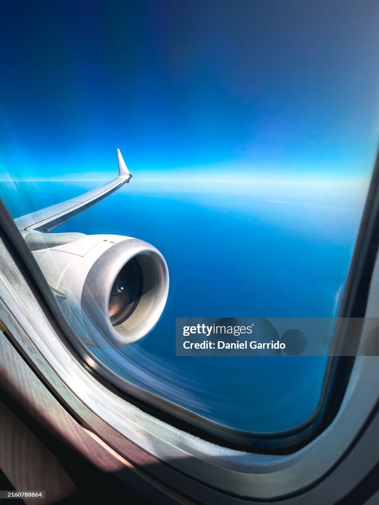 First person view of the airplane engine in flight from the window.