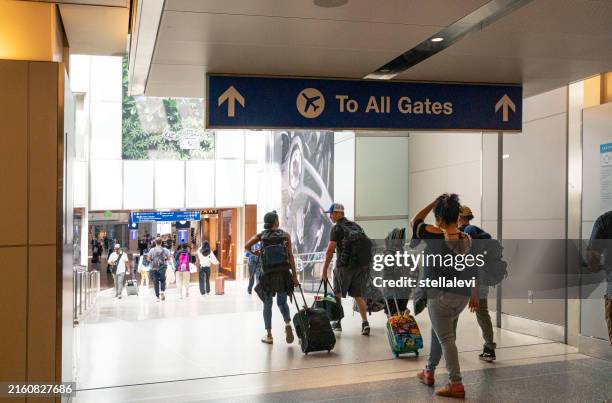 all gates sign at the airport with travelers walking to gates - los angeles international airport stockfoto's en -beelden