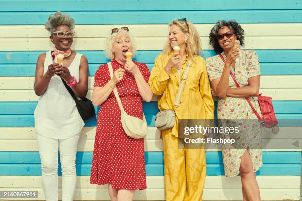 four mature women eating ice cream cones. - women holiday stock pictures, royalty-free photos & images