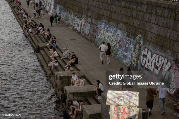 People rest on the embankment on Dnipro river on June 27, 2024 in Kyiv, Ukraine.