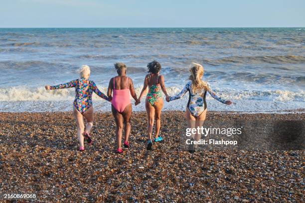 a group of mature women in swimwear at the beach. - 55 59 years stock pictures, royalty-free photos & images