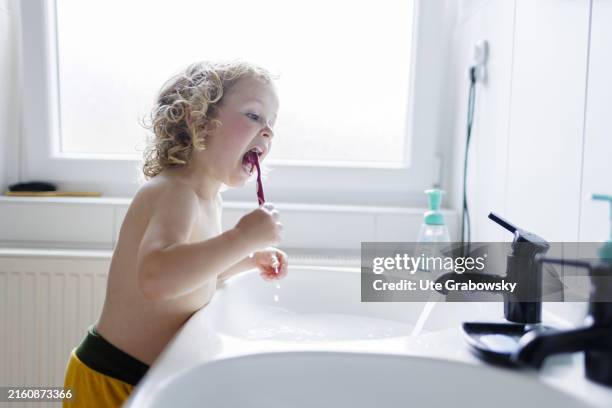 In this photo illustration a child is in the bathroom to brush its teeth on July 10, 2024 in Bonn, Germany.