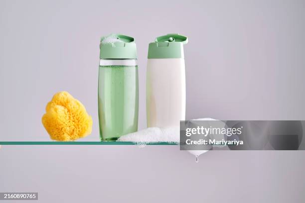 shampoo and hair conditioner on a glass shelf in the bathroom. - shampoo stock pictures, royalty-free photos & images