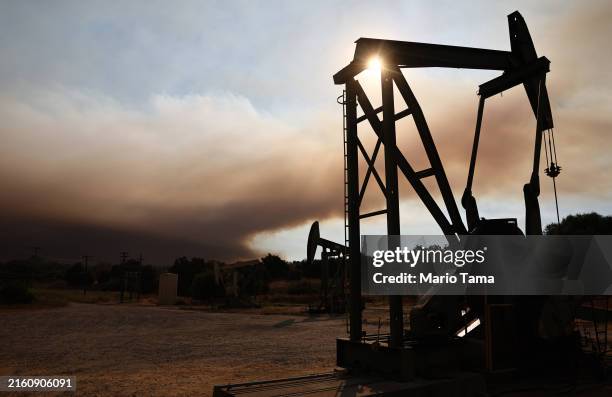 Oil pumpjacks operate as the Lake Fire burns in Los Padres National Forest with evacuation warnings in the area on July 6, 2024 near Los Olivos,...