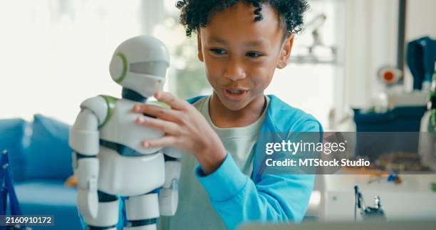 closeup of young african-american boy meticulously assembles and adjusts robotic arm, showcasing his engagement with stem learning in home workshop. stem education robotics courses online. - cyborg stock pictures, royalty-free photos & images