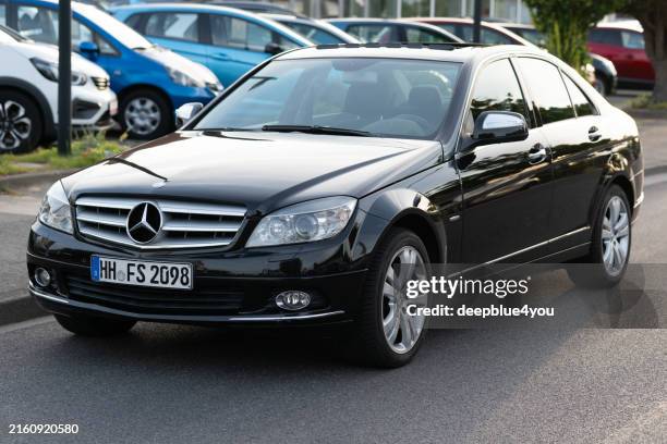 black mercedes-benz c-class in parking lot - mercedes benz stock pictures, royalty-free photos & images