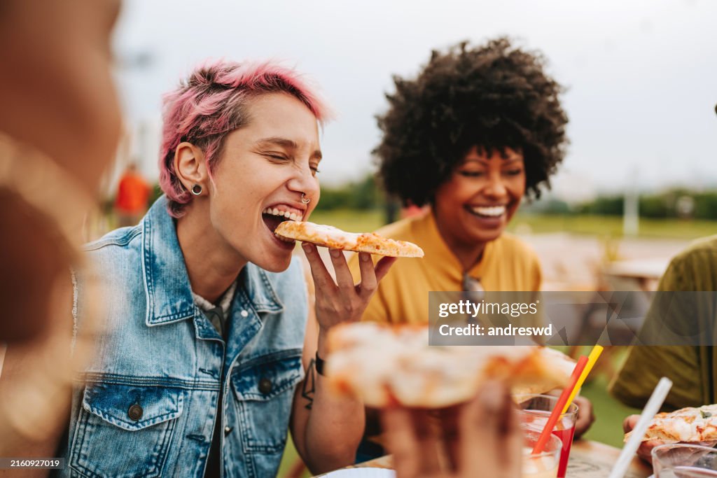 Group of friends eating pizza having fun