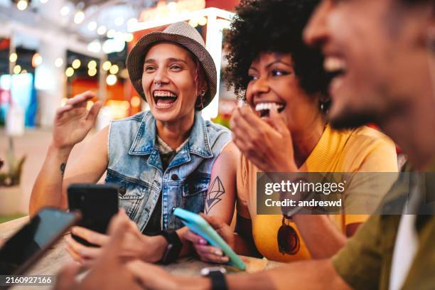 gruppe von freunden am tisch mit smartphone - subkultur stock-fotos und bilder