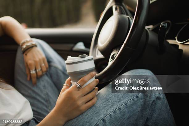 reusable travel mug with coffee in female hand in car - disposable cup stock pictures, royalty-free photos & images