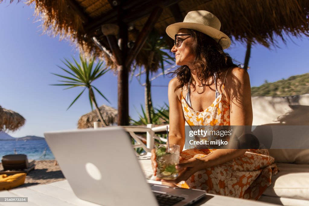 Mujer sentada en un chiringuito tomando un descanso del trabajo