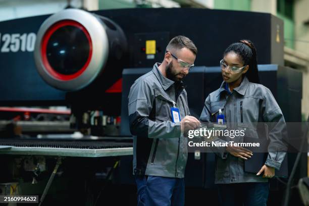 preventive machine downtime and failures with predictive maintenance in manufacturing process. a diversity of maintenance engineers in discussing predictive maintenance planning by a tablet in an engineering part production line. - resourceful stock pictures, royalty-free photos & images